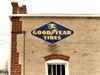 Vintage Goodyear Tires sign on the side of the auto repair shop wall.